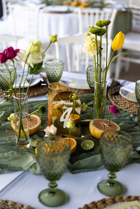 Centro de mesa con flores y copas verdes